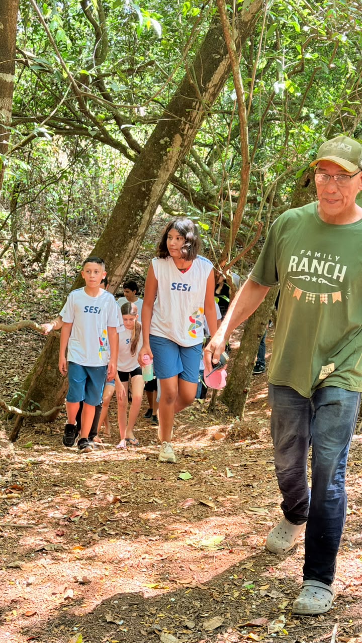 Alunos caminhando na trilha acompanhados por um guia do rancho