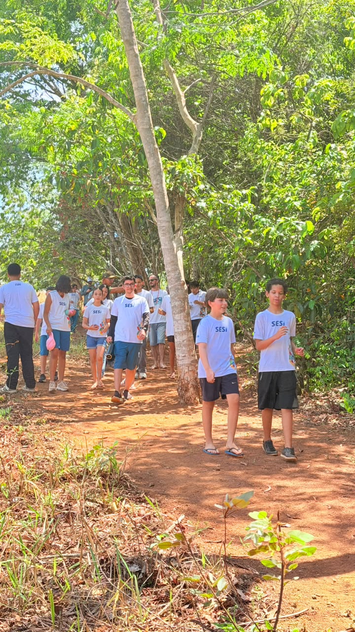 Grupo de estudantes caminhando pela trilha de terra